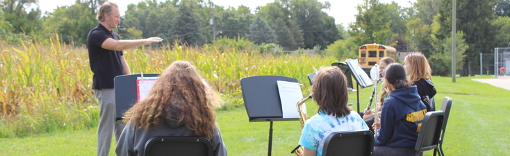 Band director Gary Franks leading a band practice outdoors